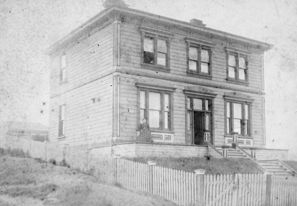 Woman on Verandah of Large Wooden House