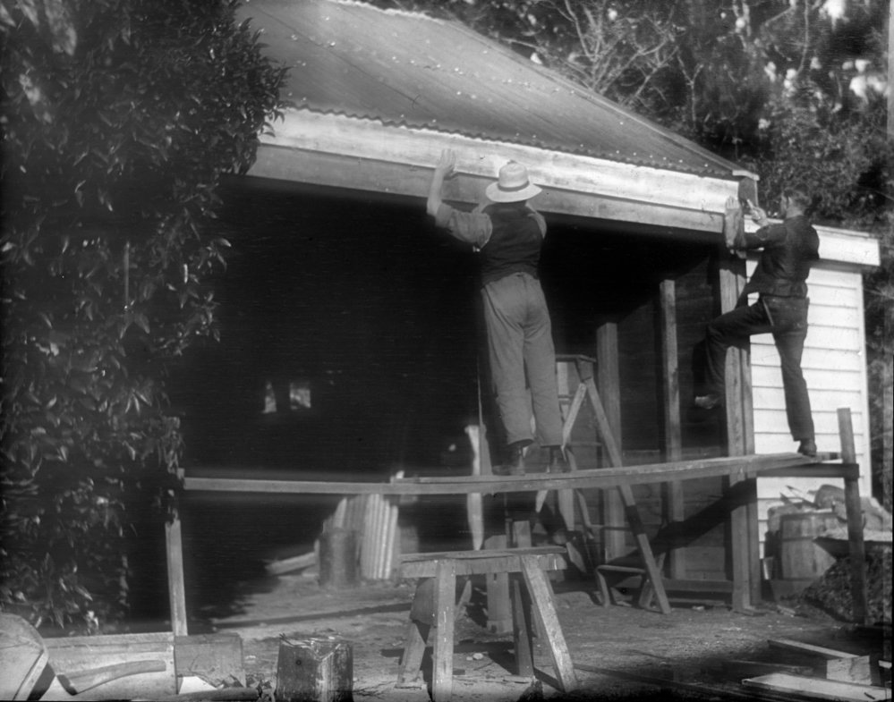 Two Men Constructing a Building.