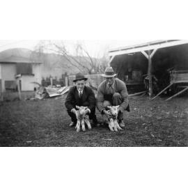 Two Men Holding Lambs